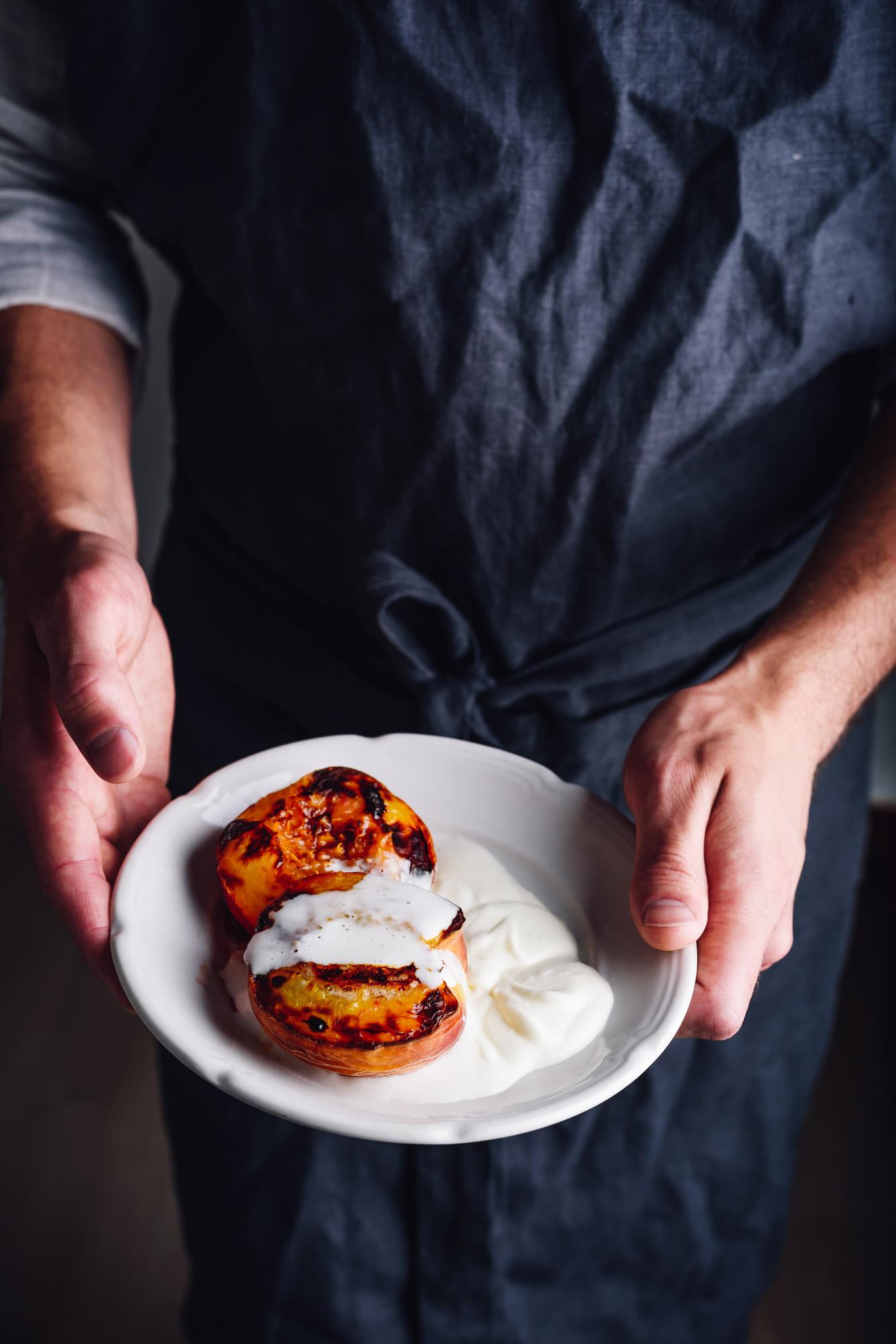 Instructor plating a rustic dish in a warm kitchen